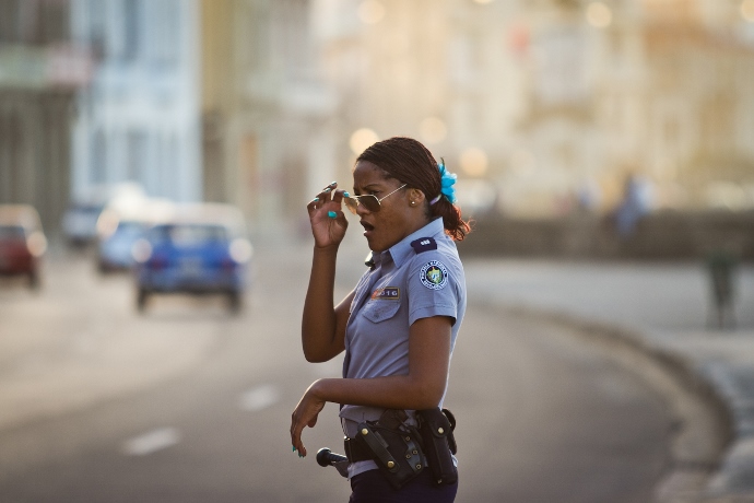 Oficial feminina da Polícia Nacional Revolucionária observa o movimento da avenida Malecón